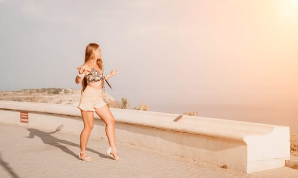 silhouette of a happy woman who dances, spins and raises her hands to the sky. A woman is enjoying a beautiful summer day.