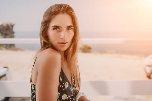 Happy woman portrait in cafe. Boho chic fashion style. Outdoor photo of young happy woman with long hair, sunny weather outdoors sitting in modern cafe