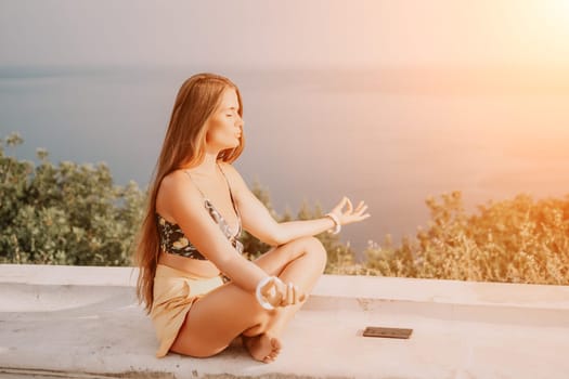 Woman park yoga. Side view of free calm bliss satisfied woman with long hair standing in morning park with yoga position against of sky by the sea. Healthy lifestyle outdoors in park, fitness concept