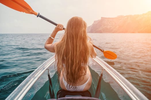 Woman in kayak back view. Happy young woman with long hair floating in transparent kayak on the crystal clear sea. Summer holiday vacation and cheerful female people having fun on the boat.