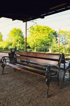 Railway station with empty bench. The way forward railway for train. Empty Railway track for locomotive. Transportation system Nature background around. travel tourist concept