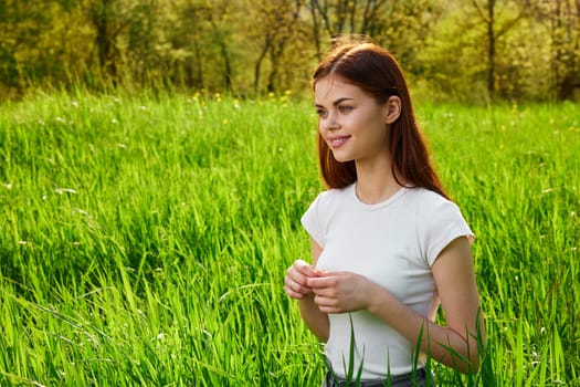 portrait of a woman sitting in tall grass and lit by the sun from the back. High quality photo