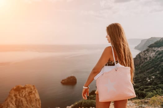 Woman travel sea. Happy tourist taking picture outdoors for memories. Woman traveler looks at the edge of the cliff on the sea bay of mountains, sharing travel adventure journey.