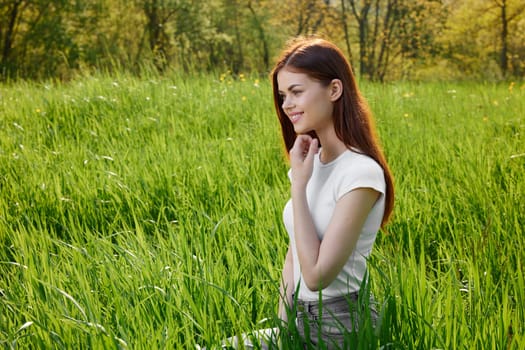 cute, happy, carefree woman sitting in tall grass. High quality photo
