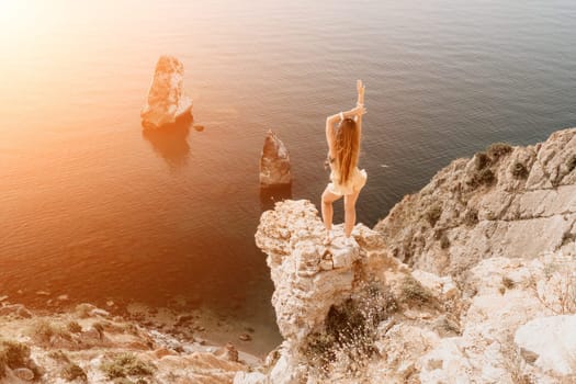 Woman travel sea. Happy tourist taking picture outdoors for memories. Woman traveler looks at the edge of the cliff on the sea bay of mountains, sharing travel adventure journey.