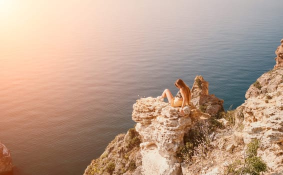 Woman travel sea. Happy tourist taking picture outdoors for memories. Woman traveler looks at the edge of the cliff on the sea bay of mountains, sharing travel adventure journey.