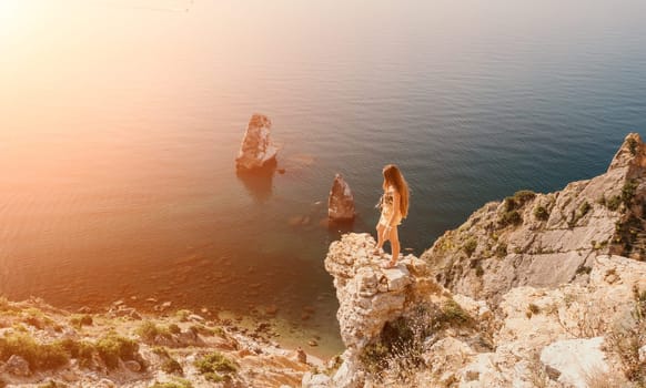 Woman travel sea. Happy tourist taking picture outdoors for memories. Woman traveler looks at the edge of the cliff on the sea bay of mountains, sharing travel adventure journey.