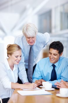 Male leader discussing with executives. Portrait of senior male leader discussing with executives at office