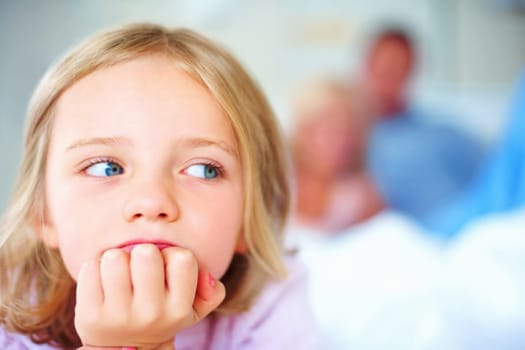 Young girl with hand on chin while blur people in background. Closeup portrait of a thoughtful young girl with hand on chin while blur people in background