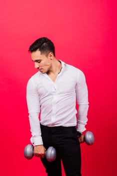 Business man with fitness dumbbells wear shirt. Studio shoot on red background