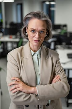 Portrait of an attractive mature caucasian woman with arms crossed on her chest in the office