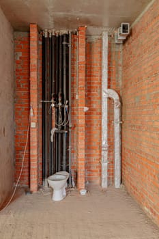 Repair and restoration of apartments. Red brick walls, concrete floors. Drain pipes and toilet