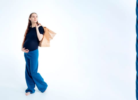 Portrait happy young pregnant woman and her husband with shopping bags and touching her big belly isolated on white background. Pregnancy shopping concept happy young family with shopping bags