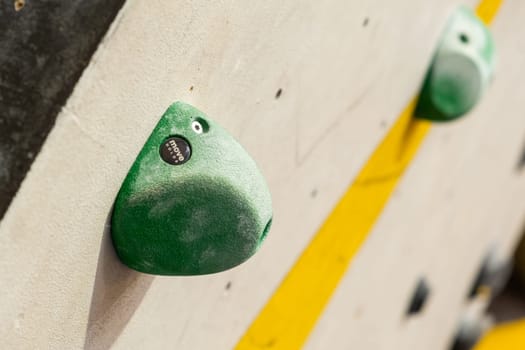 Stone hooks or grips on the artificial climbing wall in bouldering gym.