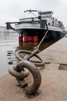 Ship or vessel moored on the embankment of the Vlatva river in Prague in cloudy and grey autumn day.