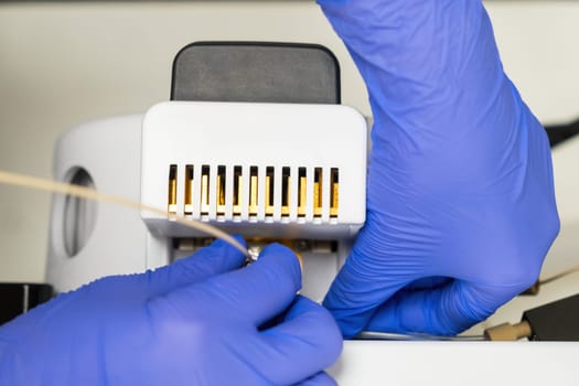 Close up laboratory worker connect a needle to the ion source of the mass spectrometer. Maintenance of mass detector. LC MS analysis in chemical or clinical laboratory.