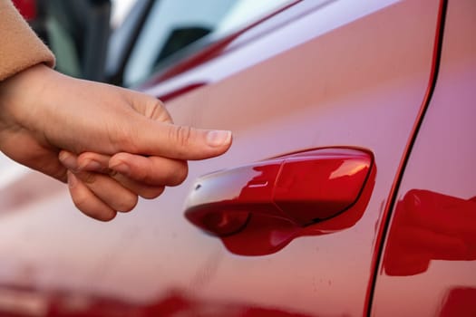 Woman closes the car by finger, close up