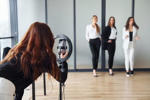 Backstage of photoshoot. Group of adult women that in formal clothes is indoors in the office together.