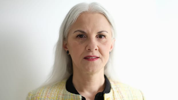 Portrait of elderly woman with long gray hair on white background. Age related skin changes concept