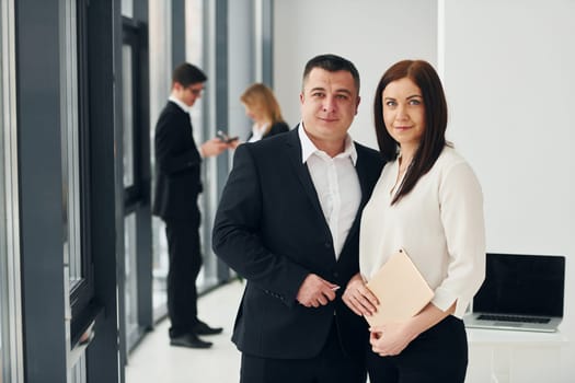 Group of people in official formal clothes that is indoors in the office.