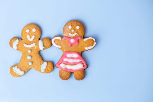 Boy and black girl gingerbread couplet on the blue background with copy space for St Valentines Day.