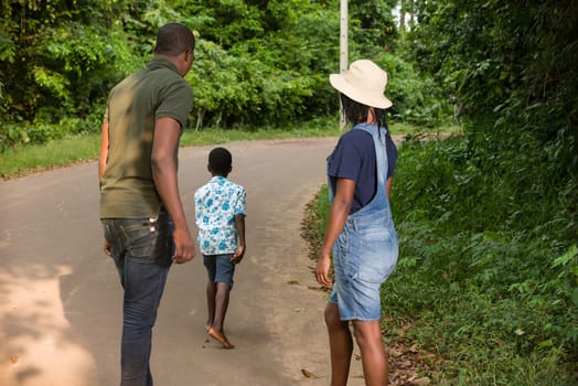 young couple standing in a park watching their child run.