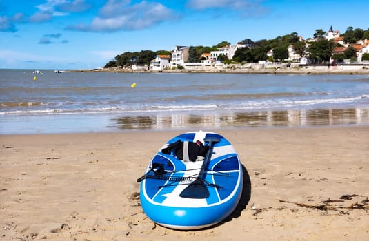 Paddle surfing board on sunny beach with beautiful view. Sea boat transportation on seacoast