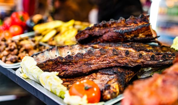 Barbecue grill meat ribs at street food market. Fresh cooking delicious bbq at traditional fair