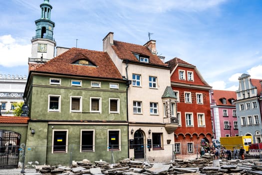 Poznan, Poland - 05 July 2022: Reconstruction of Old Market (Stary Rynek) square with small colorful houses, tourists and old Town Hall in Poznan, Poland