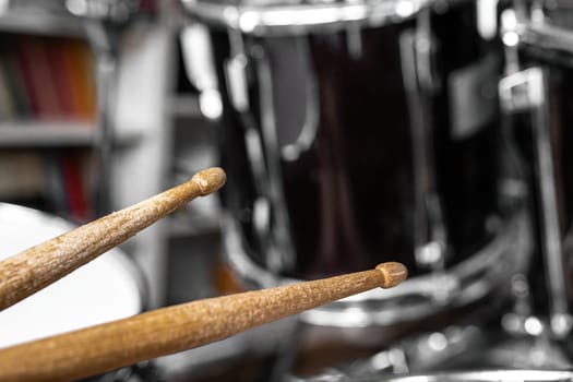 Drumsticks and drums for live music rock perfomance closeup. Wooden musical sticks for percussion instruments