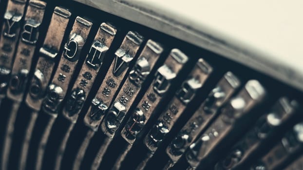 Letters and numbers on typo keys of an old manual typewriter on a retro writing machine, close up view