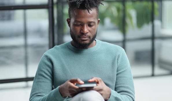 african american businessman using phone mobile corporate apps at workplace texting sms.