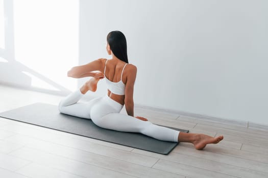 Young caucasian woman with slim body shape is indoors at daytime.