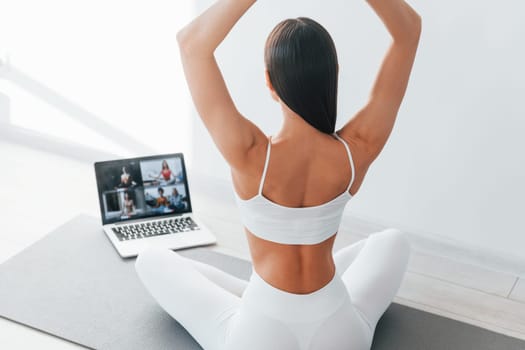 With laptop. Young caucasian woman with slim body shape is indoors at daytime.