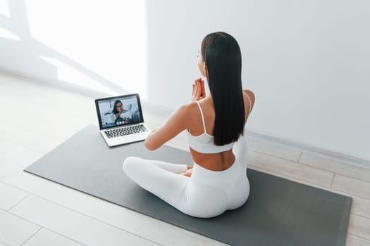 Online talking. Young caucasian woman with slim body shape is indoors at daytime.