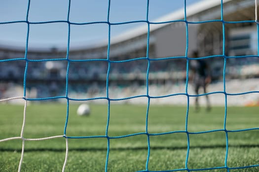 Football goal post with net, back view. Association football goal on the field