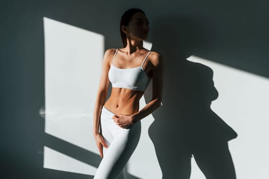 Beautiful lighting. Young caucasian woman with slim body shape is indoors at daytime.