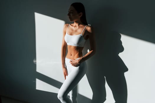 Beautiful lighting. Young caucasian woman with slim body shape is indoors at daytime.