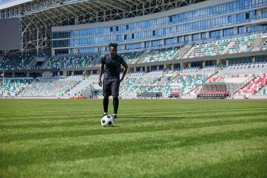 African American man playing football on the stadium field.