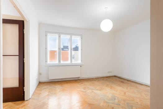an empty room in an apartment with a wardrobe and a wooden parquet floor. High quality photo