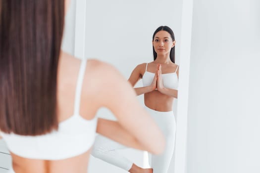 Young caucasian woman with slim body shape is indoors at daytime.