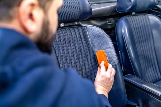 cleaning leather car seats with a brush and chemicals.