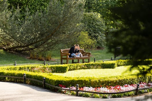 Attractive young woman reading book while sitting on grass in green public park. Springtime outdoors. Greenery unity with nature. Spend free time on open air. Education concept