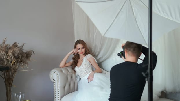 Girl model in a white dress posing in front of the photographer