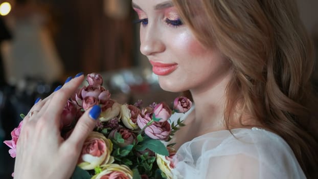 Beautiful young girl with a bouquet of flowers.