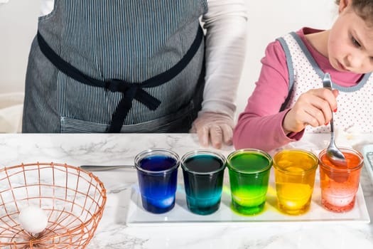 Easter egg coloring. Dye white organic eggs in different colors for Easter.