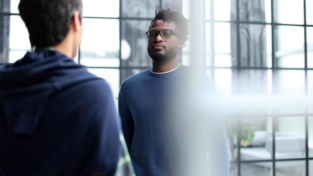 Business people talking near glass wall in office