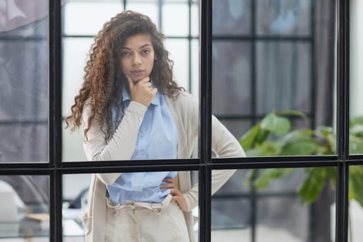 from behind the glass. young business woman thinking about something