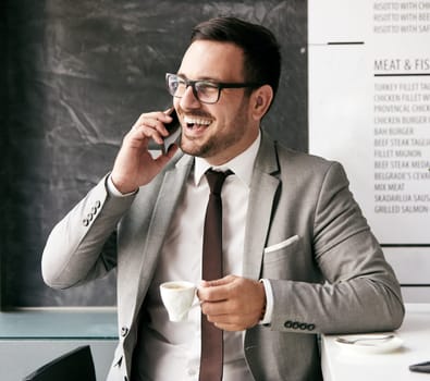portrait of a young businessman drinking coffe and talking on cell phone i na restaurant coffee bar
