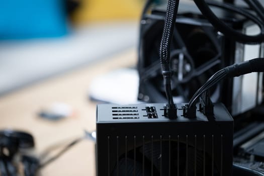 Connecting new parts to a computer to increase its performance. A heat sink equipped with a fan. Computer parts standing on a table. Active cooling of the processor.
